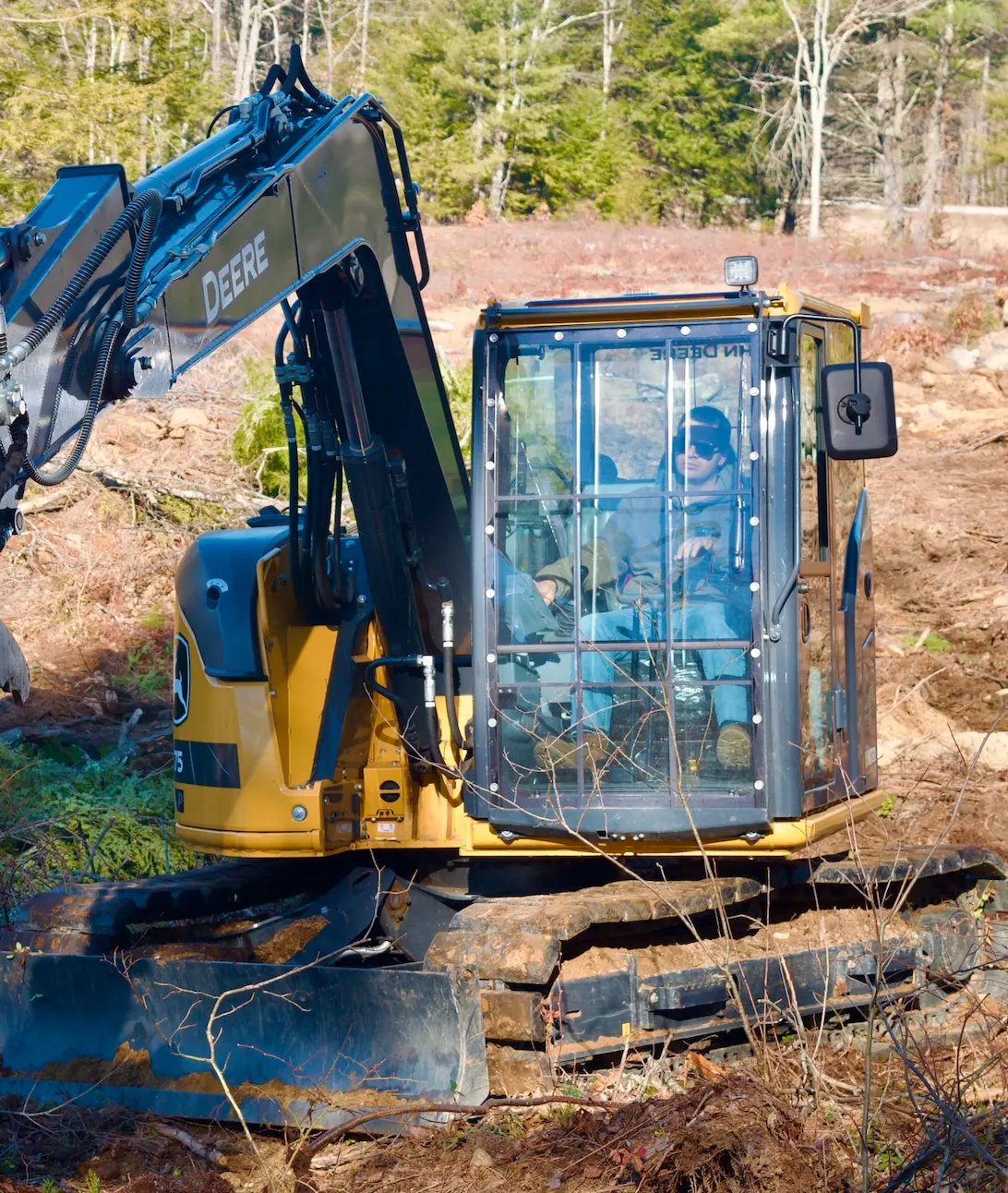 Excavator from Seacoast Land & Brush Services clearing a treeline on a property