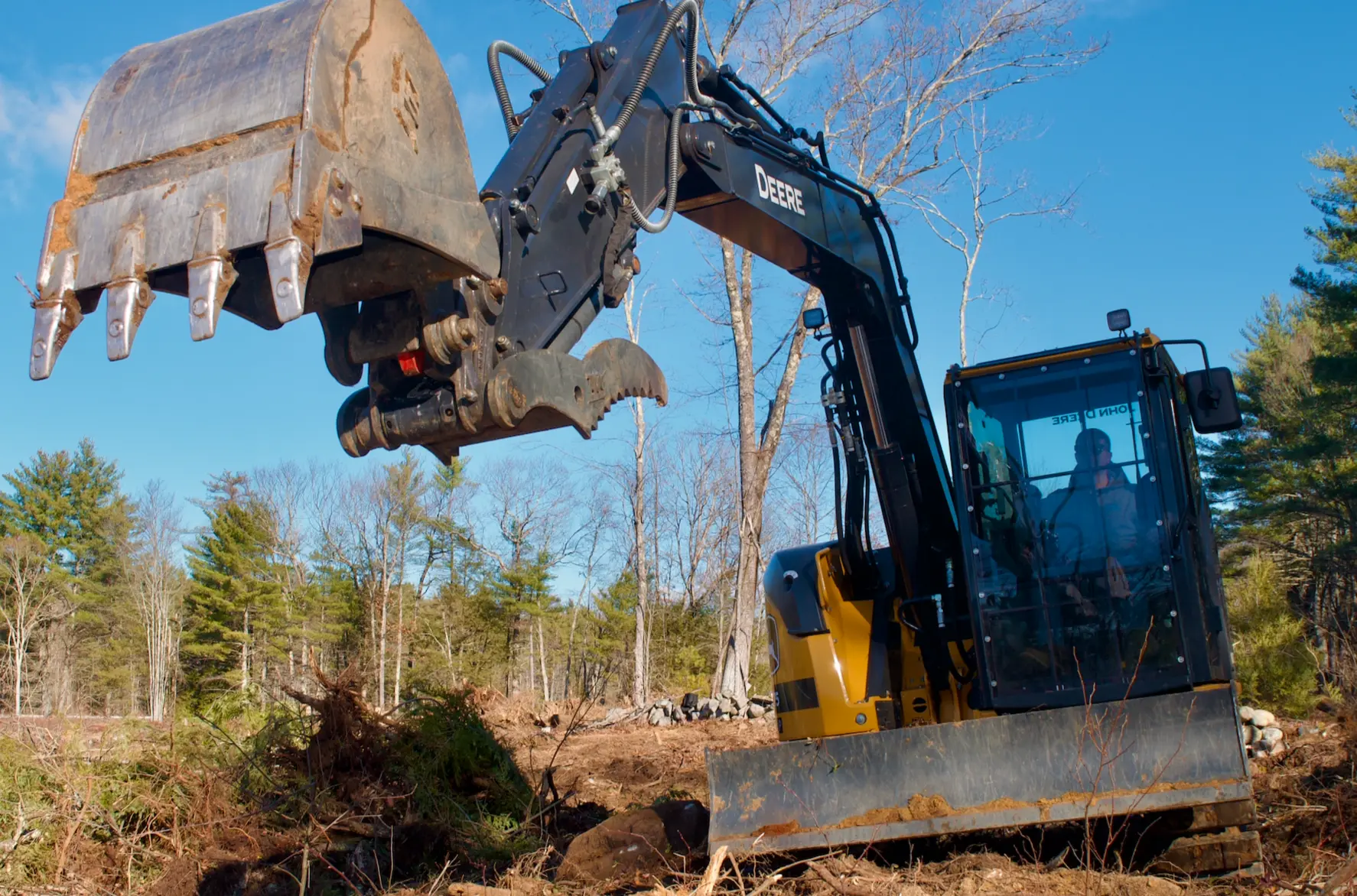 Excavator working on a cleared New England property